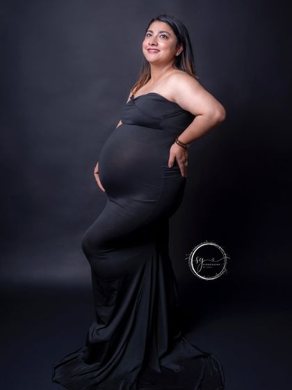 A happy and confident pose from the mom-to-be. Her smile lights up this simple yet elegant portrait in a classic black gown.