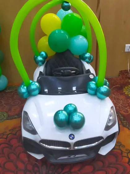 A fun addition to the jungle party: a toy car decorated with balloons for the birthday boy's entry.