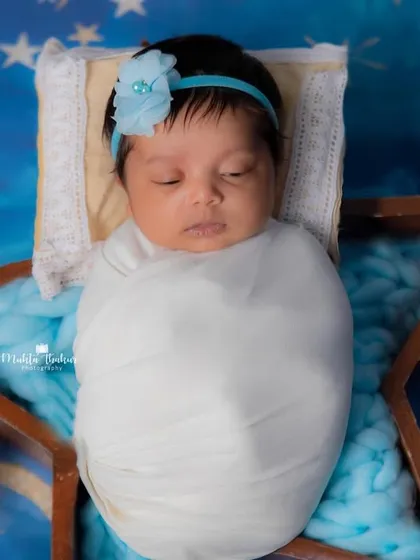A close-up of this little dreamer. The soft blue tones and starry background create a serene and beautiful newborn portrait.