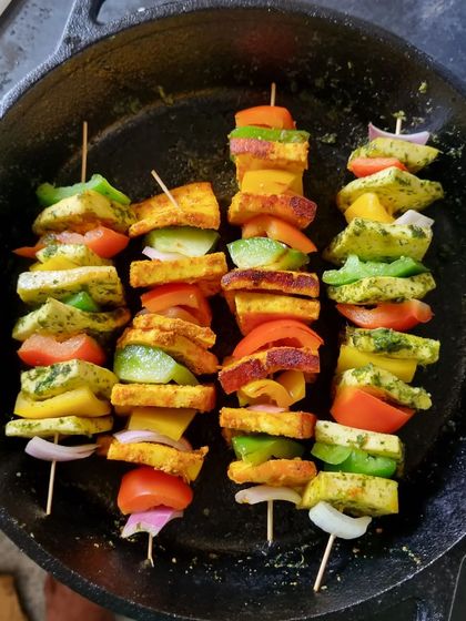 A close-up of the grilled paneer skewers, showing the colorful vegetables and perfectly cooked paneer.