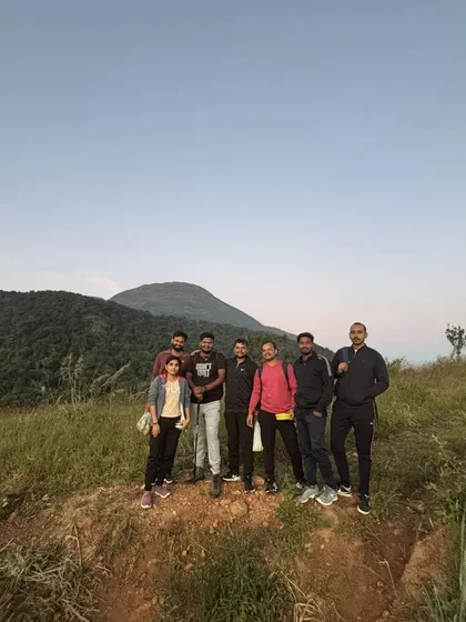 A small group posing on the trail with the mountain peak visible in the background.