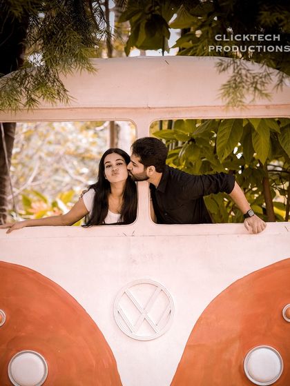 A playful kiss in our vintage VW bus prop, perfect for a fun, retro-themed couple's photoshoot.