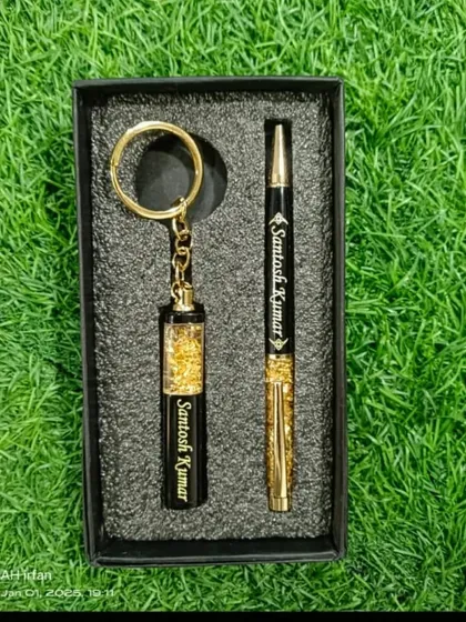 A luxurious personalized pen and keychain set, both featuring a gold flake design and custom name engraving.