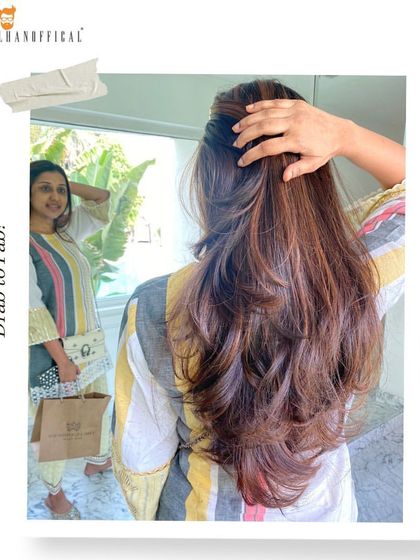 The "after" shot of a mocha balayage transformation. The client is checking out her new look, which features rich, chocolatey hues and subtle highlights.