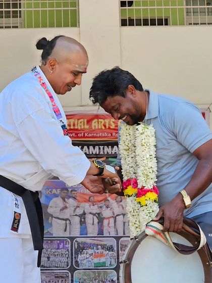 A moment of mutual respect and celebration. Here, a fellow instructor is being honored with a garland during one of our events.