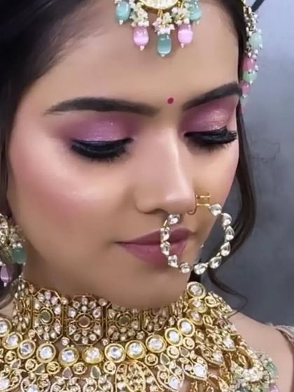 Another angle of this pastel bridal look, focusing on the shimmering eye makeup and the perfectly shaped brows that frame the face.