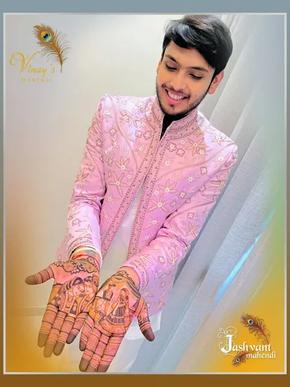 The groom showing off his detailed varmala and Radha-Krishna mehndi. It's a proud moment to wear art that tells a story.