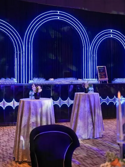 The bar area for the celestial-themed night featured a striking backdrop of three neon arches, creating a chic and modern space for guests to gather.