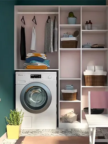A balcony converted into a compact and organized laundry space. The design features a washing machine neatly tucked under a counter with open shelving above for storing detergents and hanging clothes.