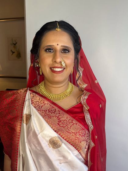 Another angle of the bride in her traditional Gujarati wedding attire, showing the beautiful details of her saree and jewelry.