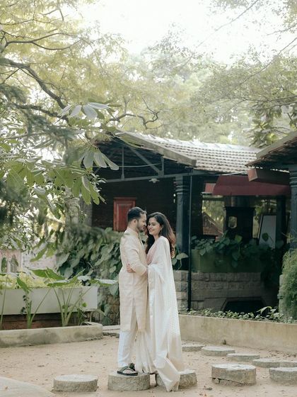 A couple stands on the stone steps in our garden, surrounded by the natural, untamed beauty of the foliage.