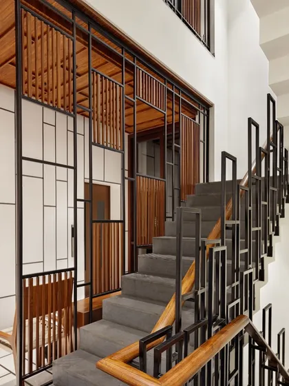 The staircase at the B-10 Residence is a key design feature. The clean lines of the metal framework harmonize with the warmth of the timber handrail, creating a visual balance that connects the different levels of the home.