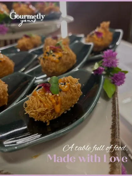 "A table full of food, made with love." This close-up shot of our crispy noodle-wrapped appetizers emphasizes the craft and care that goes into each bite.