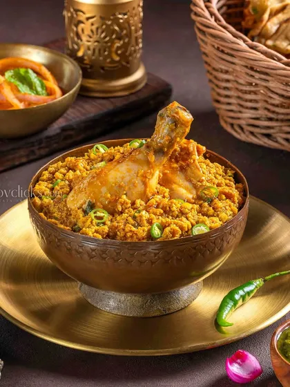 Chicken Korma Keema, a rich and flavorful dish from The Mughal House. The brass bowl and traditional props add to the authenticity of this Mughlai specialty.