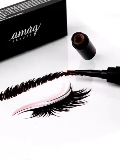 This creative shot demonstrates the product in action. The eyebrow pen creates a perfectly illustrated brow on a clean white surface, showcasing its precision and rich pigment in a visually engaging way.