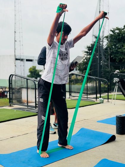 An athlete performs a resistance band exercise as part of his warm-up routine before a tournament. Proper activation is key to performance and injury prevention.