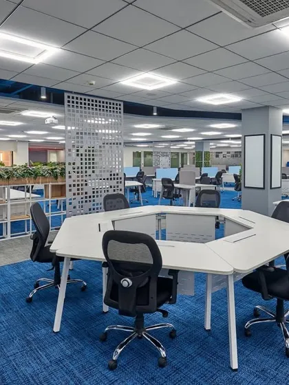 These hexagonal desks can be reconfigured into various arrangements, offering maximum flexibility for team-based work. The bold blue carpeting adds energy to the space.