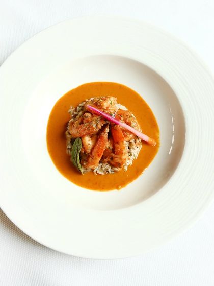 Braised prawns are served on a bed of red rice with a smoked chilli and raw mango curry. It’s a comforting and hearty dish, perfect for a flavourful meal.