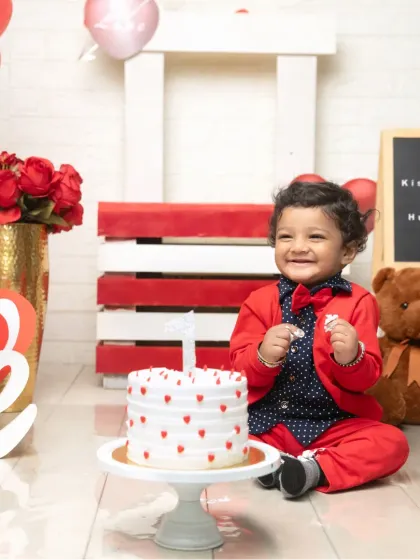 A joyful laugh surrounded by hearts and roses. The red and white theme with a cute teddy bear creates a perfectly loving atmosphere for a Valentine's baby.