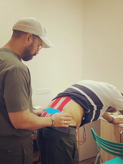 Here I am applying kinesio tape to a client with low back pain. This taping method provides support and pain relief without restricting movement, making it ideal for people who need to stay active.