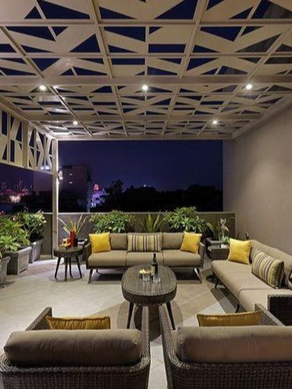 This is how we create ambiance for the perfect evening. This modern terrace features a geometric designer pergola with integrated lighting, comfortable lounge seating, and lush planters, turning the space into a stylish, functional area for nighttime entertaining.