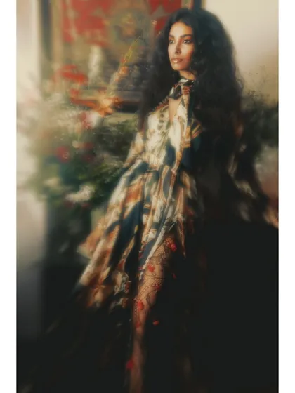 A motion-filled shot from 'Roots'. The blur effect on the floral background and flowing dress creates a dreamlike atmosphere, suggesting that our roots are tied to memories and emotions.