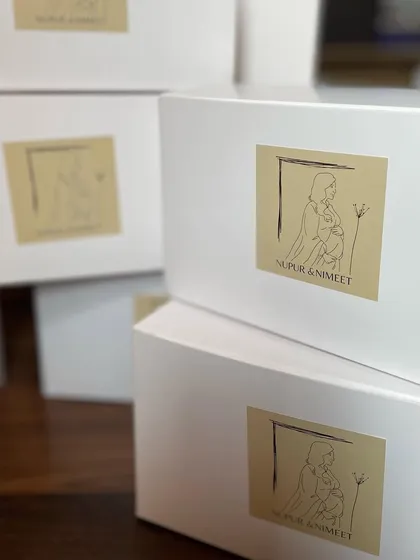 A stack of our custom-designed boxes for a baby shower favor order. The simple, clean design with a personalized sticker looks modern and heartfelt.