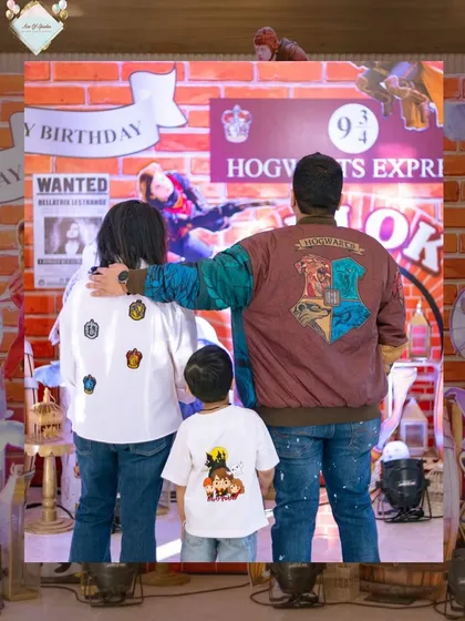 A heartwarming photo of the family from behind, showing off their custom Harry Potter-themed outfits with house crests.