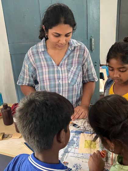 An instructor guiding children through a creative activity during a community outreach program. We are passionate about sharing the joy of making art with the next generation of creators.