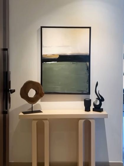 A serene, minimalist landscape painting installed in a Mumbai entryway. The simple composition of green, black, and beige creates a very calming and welcoming first impression.