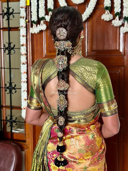A detailed shot of the traditional braid, adorned with multiple intricate gold hairpieces.