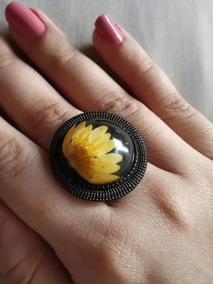 Here is another one of my daisy rings, this time with a bright yellow flower. The dark, ornate setting provides a beautiful contrast to the cheerful bloom inside.