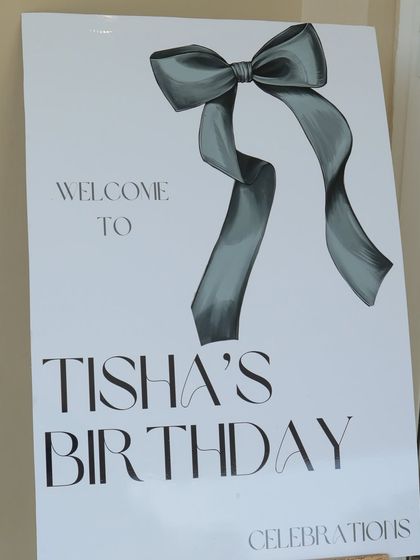 The welcome sign for "Tisha's Birthday," featuring a stylish, hand drawn bow design. This custom signage set the tone for a chic and elegant celebration from the moment guests arrived.