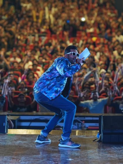 Getting low to connect with the front rows. As an anchor, it's crucial to engage every part of the audience, from the front to the back.