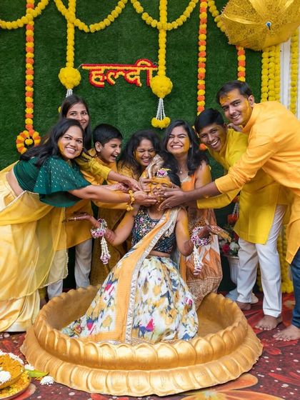 The bride surrounded by her family during a joyful Haldi ceremony.