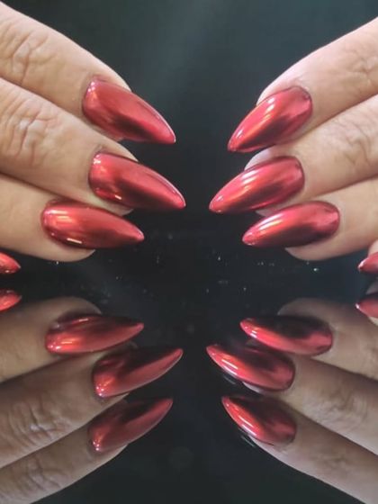 The perfect red chrome manicure, showing off the brilliant shine and flawless application.