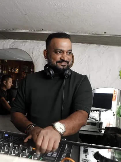 A candid shot of me smiling behind the decks. This is me in my happy place, surrounded by music and good energy.