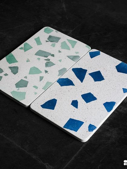 New Venetian terrazzo designs featuring bold blue and green stone chips against a clean white background. These are available in large format tiles for a seamless look.