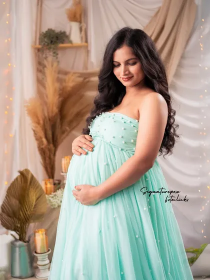A quiet, contemplative portrait in the mint gown, set against the warm, textured boho backdrop.