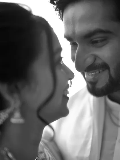 Sometimes, the most powerful stories are told without color. This black and white portrait captures a simple, honest connection between the couple, focusing purely on their expressions and the love they share. It's an example of our artistic approach to wedding photography.
