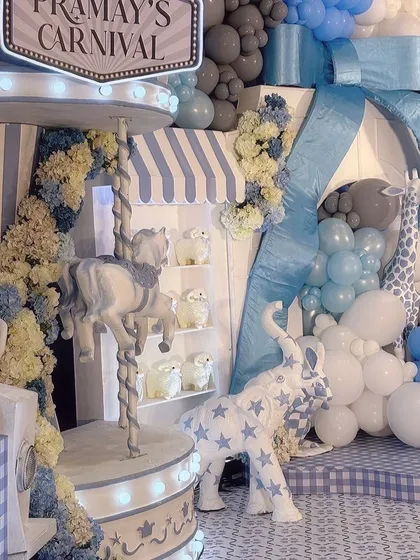 A close-up of the carnival carousel, with detailed horses and a custom 'Pramay's Carnival' sign. This setup includes adorable animal props like a star-patterned elephant.