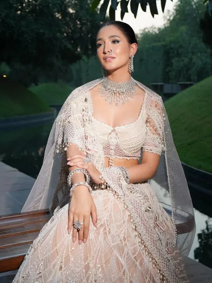 Working with master couturiers like Tarun Tahiliani is about respecting the craftsmanship. I styled this ethereal, pearl-white lehenga to emphasize its delicate textures and flow. The minimal diamond jewelry and soft styling create a look of sophisticated, understated luxury.