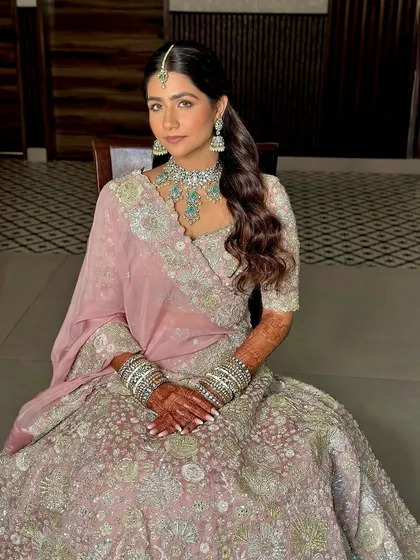 A seated portrait of my pastel bride. The soft pink tones of her makeup perfectly complement her Mishru lehenga and turquoise jewelry.