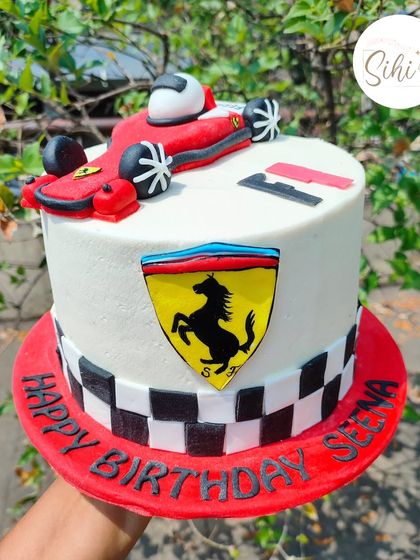 Zoom past you. A Ferrari F1 race car cake for a speed enthusiast. The design includes a hand-sculpted fondant car, the Ferrari logo, and a checkered flag border.