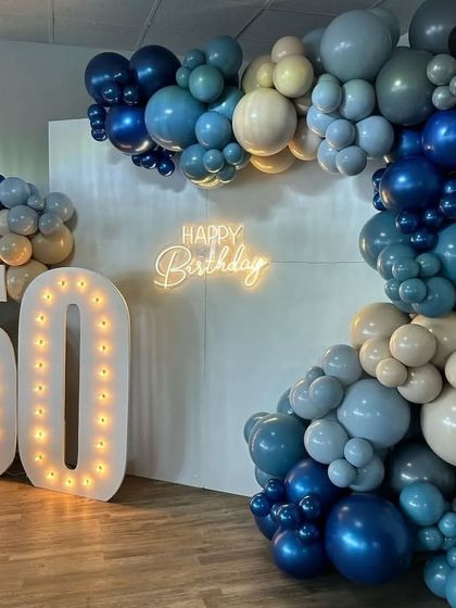 A closer view of the sophisticated 50th birthday decor. This shot highlights the beautiful gradient of colors in the organic balloon garland, from deep navy to soft beige.