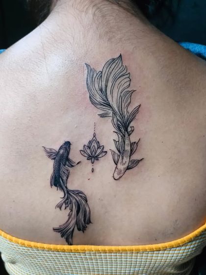 A beautiful back piece featuring two koi fish and a lotus flower. In Japanese culture, koi fish symbolize perseverance and strength, making this a deeply meaningful tattoo.