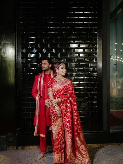 A regal portrait of a couple in their stunning red Bengali wedding attire. We celebrate love stories from all cultures.