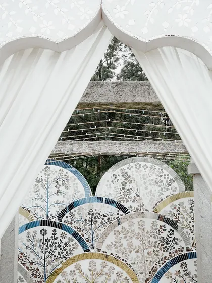 A detail of the Thikri work, seen through a draped archway. The craftsmanship is evident in the intricate patterns, each piece of mirror hand-cut and placed to create a stunning mosaic.