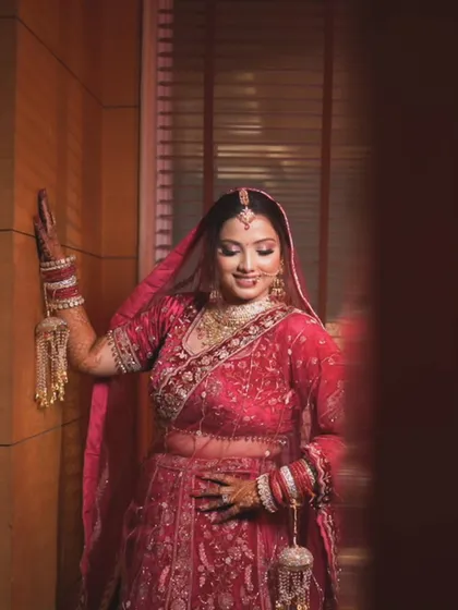 A full-length shot of the bride, capturing a quiet moment of reflection. The soft lighting and composition give it a very calm feel.