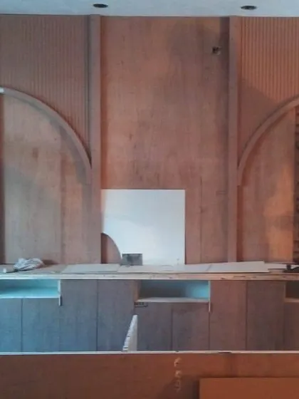 The reception back wall during the fabrication stage. Here you can see the raw plywood and framework being assembled on-site before the final finishes are applied, showing the craftsmanship behind the design.